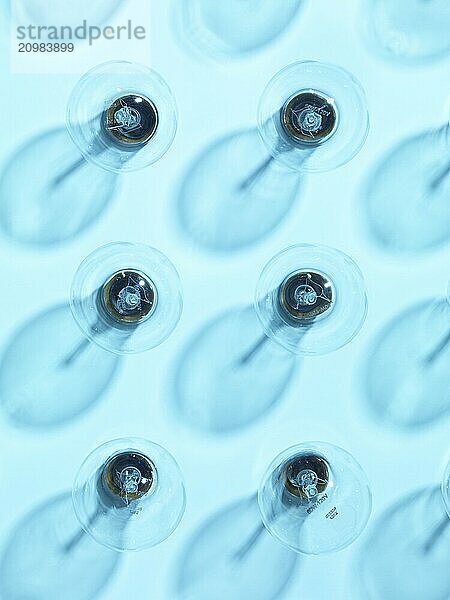 Six turned off incandescent tungsten light bulbs on blue background