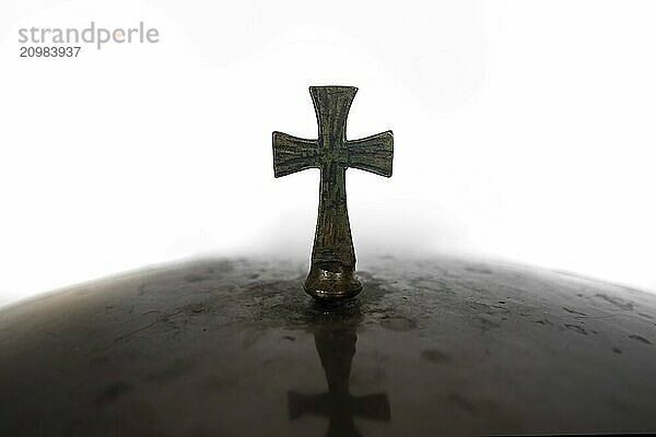 Bronze Christian cross against a white background