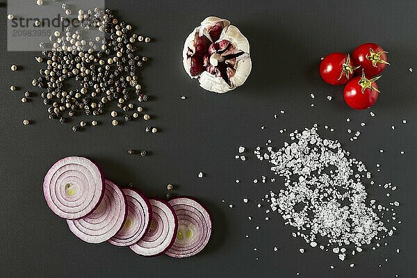 Vegetables  salt and pepper over a dark background seen from above