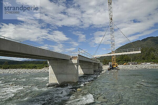 Builders construct a concrete bridge over a small river in Westland  New Zealand  Oceania