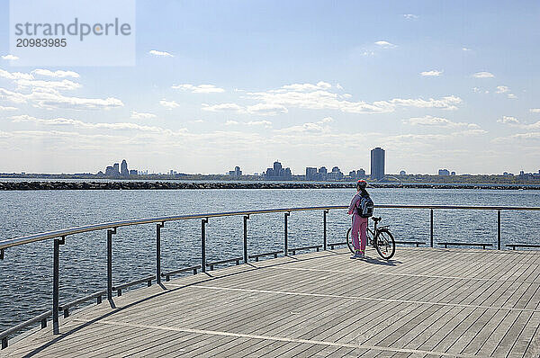 Young woman with a bicycle enjoying view of Lake Ontario from Toronto waterfront Toronto Ontario Canada Recreation and healthy lifestyle conceptual image with copyspace