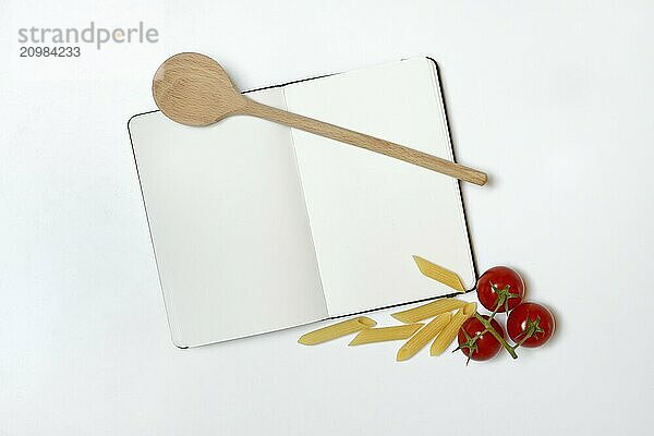 Notebook for recipes  cooking spoons  pasta and tomatoes