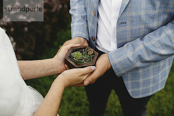 Wedding couple is holding their wedding rings.