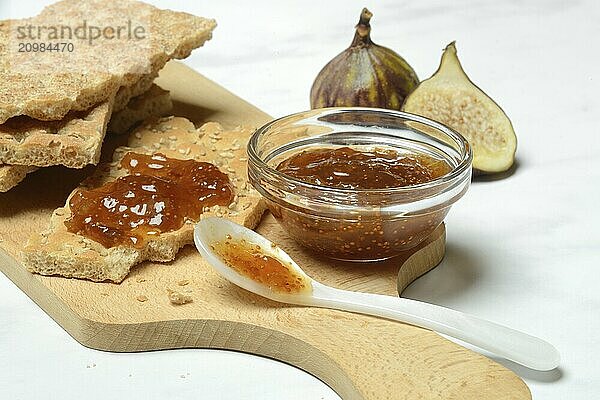 Fig jam in small bowls and on crispbread  Ficus carica