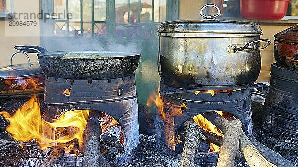 Several pots and pans cooking on open fires in a rustic kitchen  flames flickering on the logs  Drakona  Slowfood  Restaurant Dounias  Lefka Ori  White Mountains  mountain massif  west  Crete  Greece  Europe