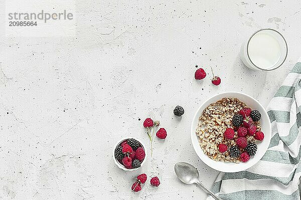 Morning healthy breakfast  white bowl full with granola  muesli  raspberry  blackberry on gray concrete table. Healthy eating  eco  bio food concept. Fresh tasty meal on grey background. Quality photo