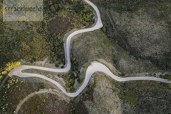 Beautiful drone aerial top view of road with curves in mountain landscape with a van social distancing near Piodao  Serra da Estrela in Portugal