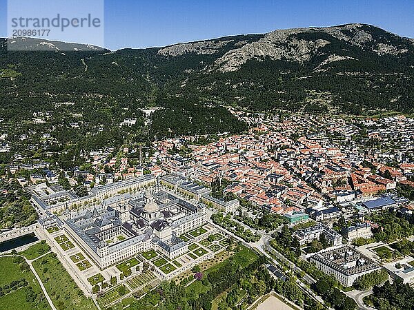 Large historic monastery and surrounding town in a green and mountainous landscape  taken from the air  aerial view  Real Sitio de San Lorenzo de El Escorial  Royal Seat of St Lawrence of El Escorial  palace and monastery complex  San Lorenzo de El Escorial  Madrid  Spain  UNESCO World Heritage Site  Europe