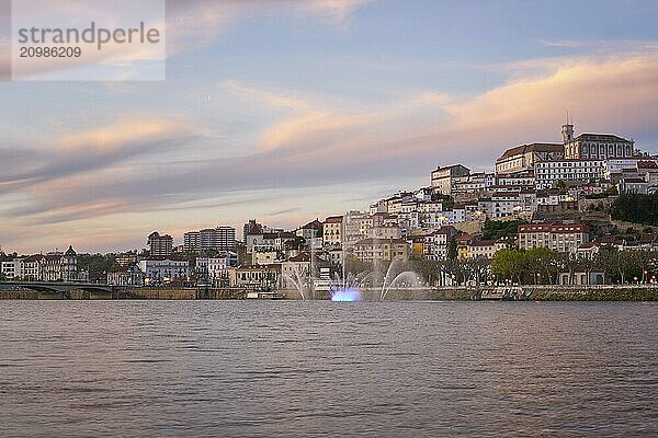 Coimbra city view at sunset with Mondego river and beautiful historic buildings  in Portugal