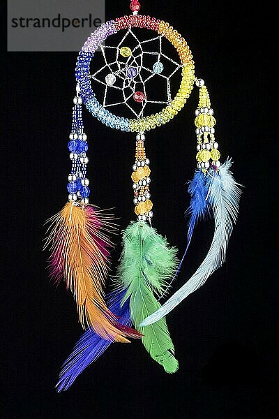 Beaded dreamcatcher with colourful feathers and beads against a black background