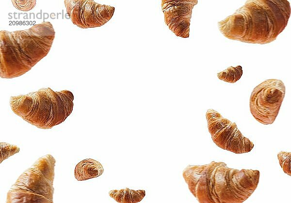 Many fresh baked croissants levitating or flying. Croissants isolated on white background with copy space in the center. Levitation scene. Bakery  confectionery advertisement. Creative breakfast food