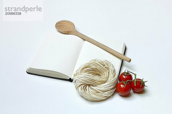 Notebook for recipes  cooking spoons  pasta and tomatoes