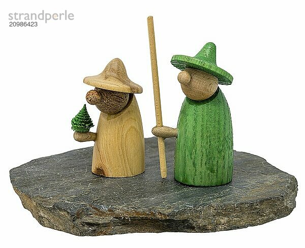 Two wooden gnome figures stand on a dark wooden board on a white background