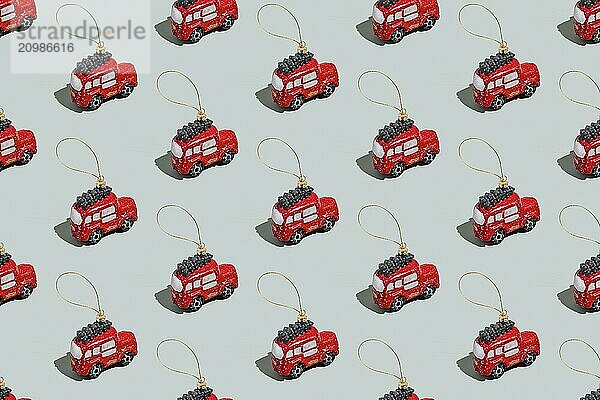 Gray green background pattern with Christmas or New Year symbol attribute objects and symbolic items concept. Small red English taxi car toy with ribbon  golden little toy fir tree.