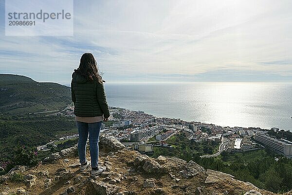 Caucasian traveler woman on a viewpoint of Sesimbra city from the city castle  in Portugal