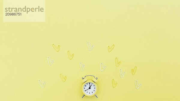 Back to school  office work conceptual flat lay with alarm clock  clips and copy space area for text. Concept of time to work  be in time and wake up early idea. Yellow background and alarmclock