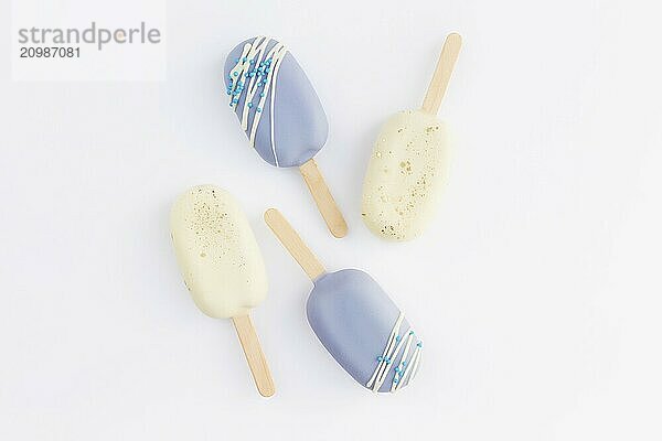 Blue and white cookie ice creams on a stick on white background.