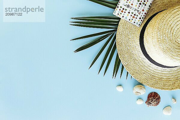 Travel  vacation concept. Hat with sea shells  palm leaf  passport on blue background.