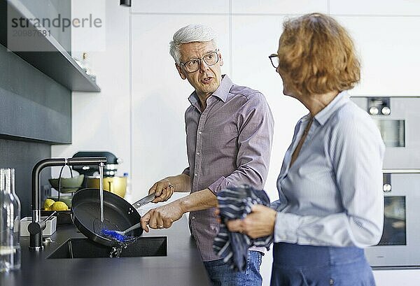 Symbolic photo. An elderly couple stand in the kitchen and do the washing up together. Berlin  13.08.2024