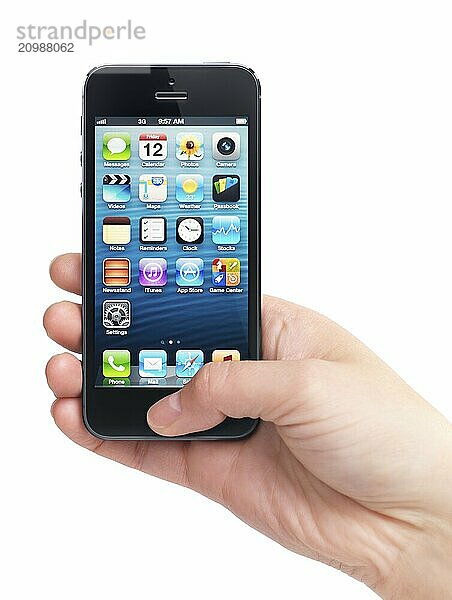 Close up of a hand holding iPhone 5 with blue desktop on its display isolated on white background