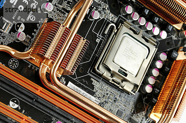 Computer motherboard with a CPU in a socket and copper heatsinks