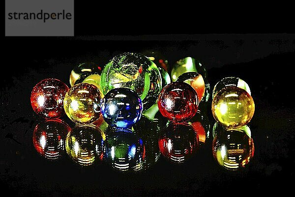 Colourful glass balls mirrored on a black background