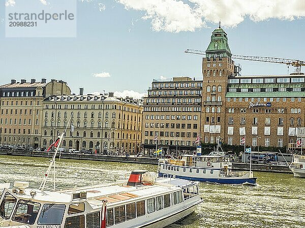 City scene with several buildings and boats on the water in sunny weather  stockholm  baltic sea  sweden  scandinavia