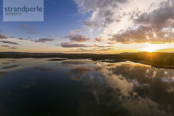 Drone aerial view of a lake reservoir of a dam with perfect reflection on the water of the sunset in Sabugal  Portugal  Europe