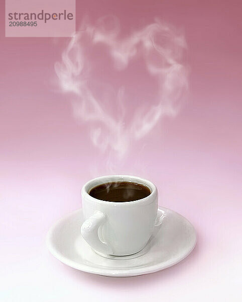 Cup of steaming aromatic black hot coffee with heart shaped steam over pink background. Valentines Day  love  romantic conceptual still life photo-illustration