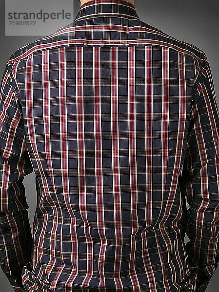 Closeup of a back of a man wearing stylish dark red tartan shirt on grey background. Rear view