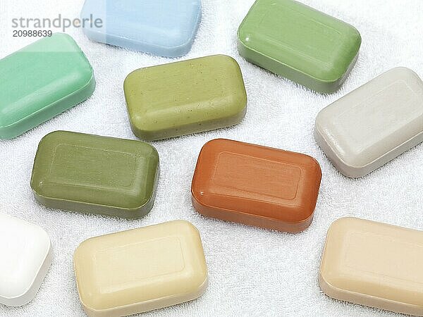 Different color soap bars with healthy natural ingredients on white background