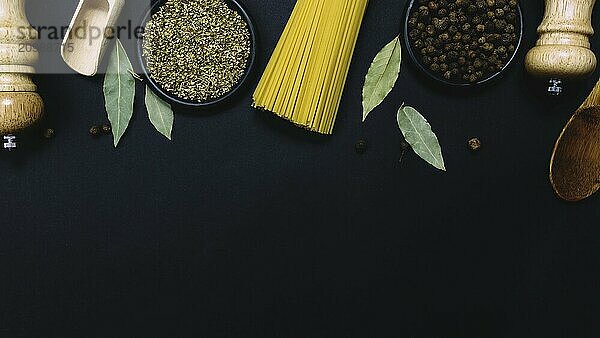 Seasonings  herbs and pasta on black background.