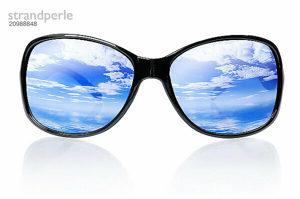 Blue skies and sea reflecting in sunglasses isolated on white background