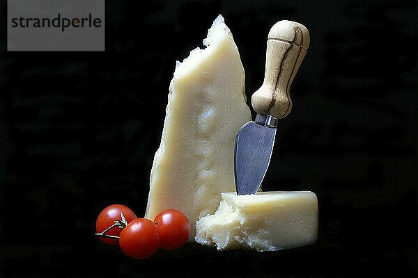 A piece of Parmesan cheese with cheese knife  tomatoes  Italy  Europe