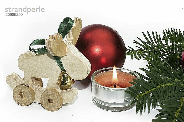 Christmas animal figurine with candle and red baubles against a white background