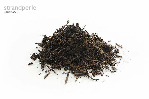 Tree bark and wood chips mulch used in horticulture and gardening. Closeup of an isolated cone pile on white studio background