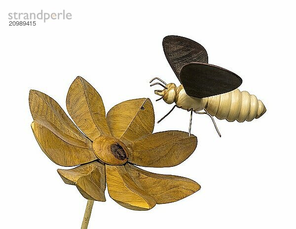 Model of a wooden bee flying towards a wooden flower  cropped on white