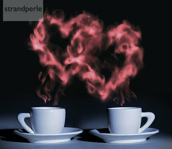 Two cups coffee with steam shaped at two hearts rising above them