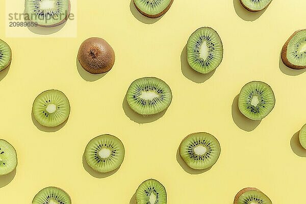 Slices and cuts of kiwi fruit pattern on yellow background. Healthy eating  travel or vacation concept