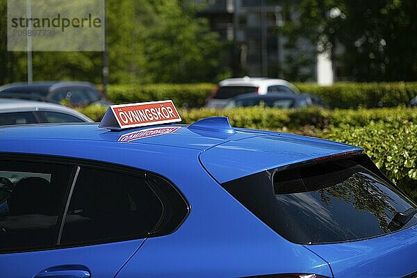 Swedish driver training sign on the roof of a blue car