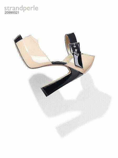 Trendy thick high heel platform shoe in mid air isolated on white background