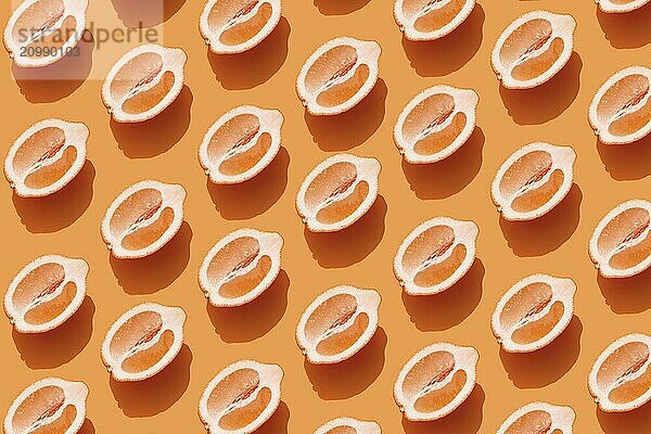 Conceptual pattern with halves of lemon with shadow on orange background. Healthy eating  travel or vacation concept