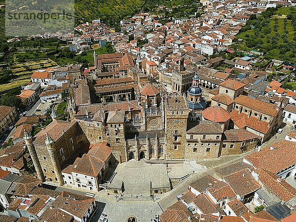 Aerial view of an old monastery with red roofs  surrounded by a village and green hills  presenting the historical architecture in Spain  Aerial view  Sanctuary and Monastery  Real Monasterio de Nuestra Señora de Guadalupe  Guadalupe  Cáceres Province  Caceres  Extremadura  Spain  Europe