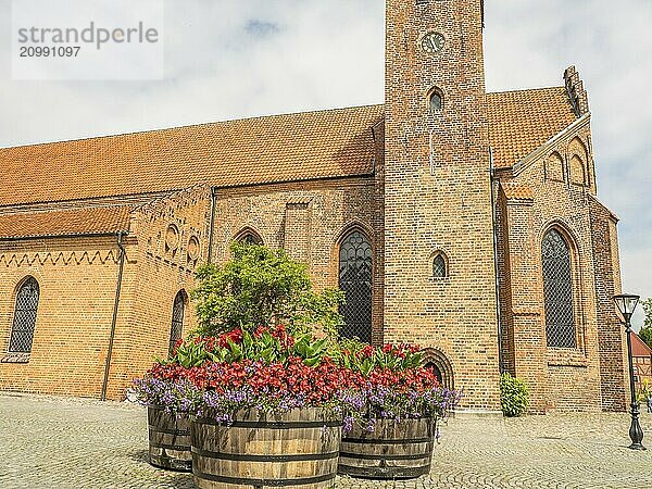 Church in the background with large flower pots in the foreground  historic brick walls  ystad  sweden  baltic sea  scandinavia