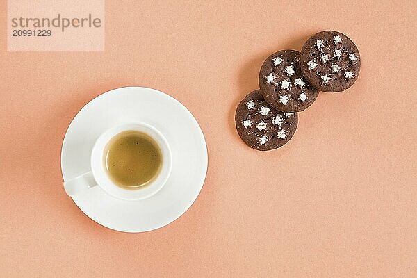 Italian espresso coffee and biscuits over a pink background seen from above