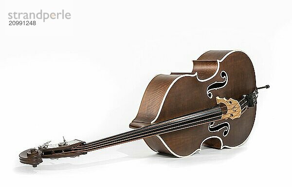 Old brown double bass lying on the floor in front of a white background