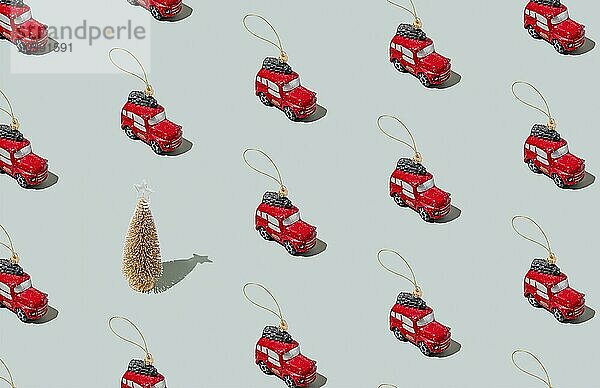 Gray green background pattern with Christmas or New Year symbol attribute objects and symbolic items concept. Small red English taxi car toy with ribbon  golden little toy fir tree.