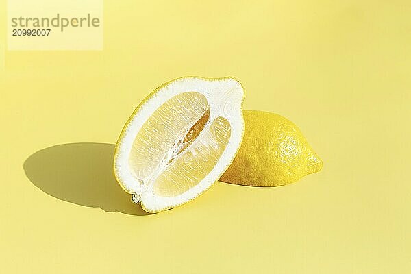 Two halved cuts of lemon with shadow on yellow background. Healthy eating  travel or vacation concept