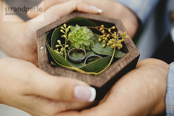 Wedding couple is holding their wedding rings.