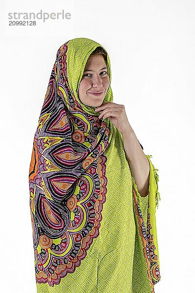 Smiling young girl with green headscarf looks into the camera cropped on white